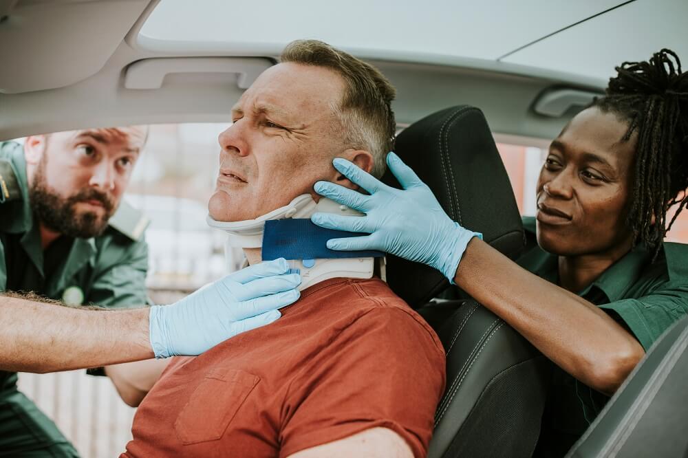 Paramedics rescuing injured driver from car crash.