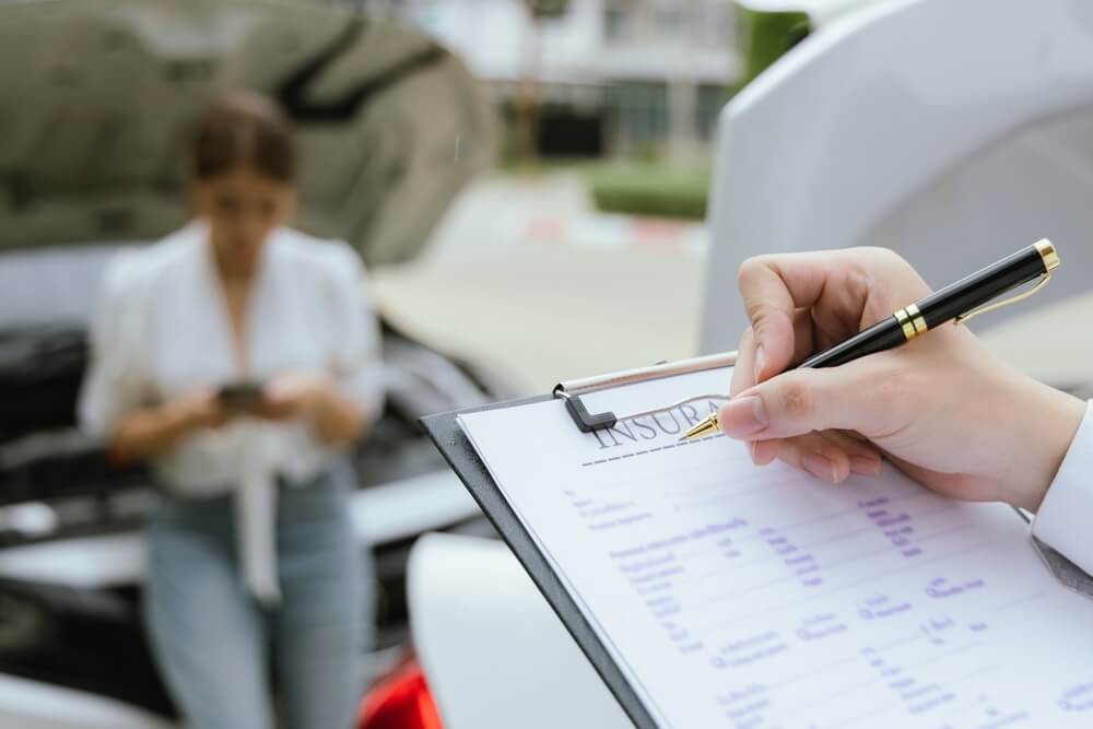 Car insurance agent checking car damages from accident.