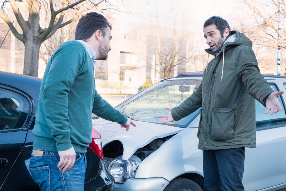 Angry drivers blaming whose at fault at car accident.