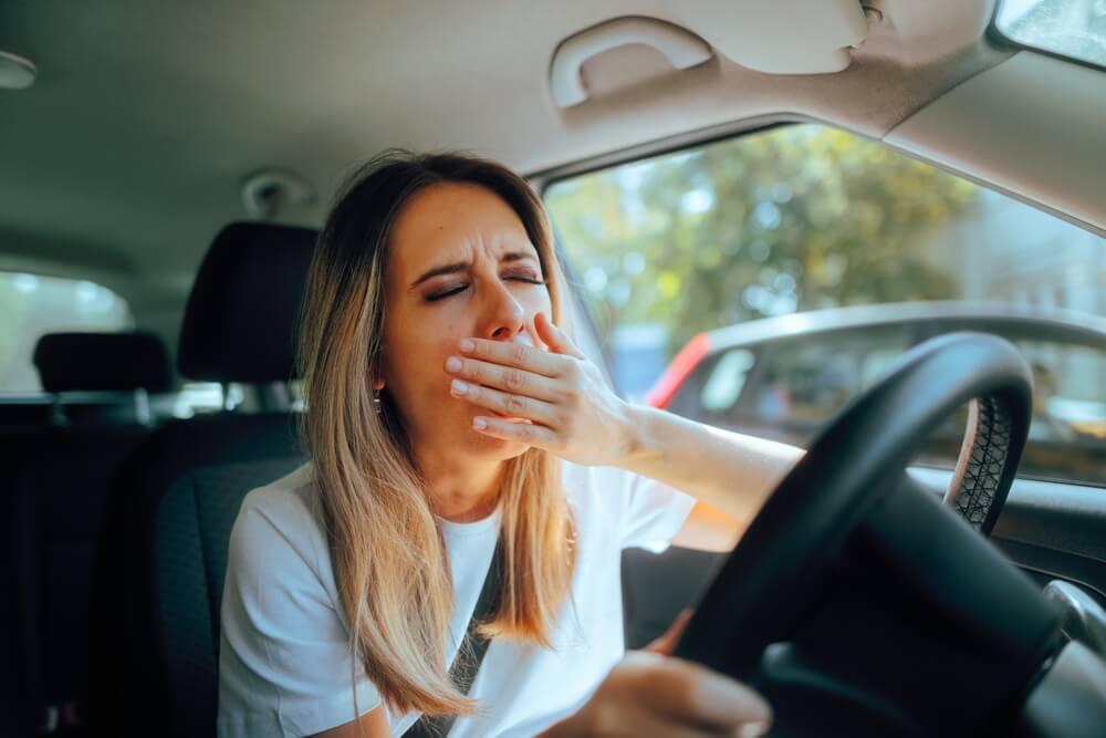 Lady driver is sleepy driving.